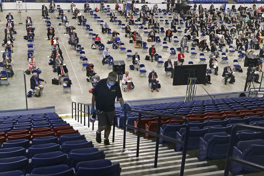 A worker disinfects a hand rail as the N.H. House of Representatives gather in Durham, N.H. on Thursday, June 11, 2020, at the Whittemore Center at the University of New Hampshire. The Legislature, which suspended its work in March because of the coronavirus outbreak, gathered at the arena for the first House session held outside the Statehouse since the Civil War. (AP Photo/Charles Krupa)