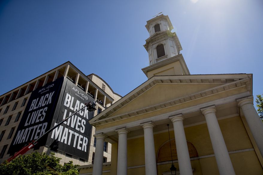 St. John&#x27;s Episcopal Church is visible as a large banner that reads Black Lives Matter is hung from the AFL-CIO building on part of 16th Street renamed Black Lives Matter Plaza, a site of protests, Friday, June 12, 2020, near the White House in Washington. The protests began over the death of George Floyd, a black man who was in police custody in Minneapolis. Floyd died after being restrained by Minneapolis police officers. (AP Photo/Andrew Harnik)