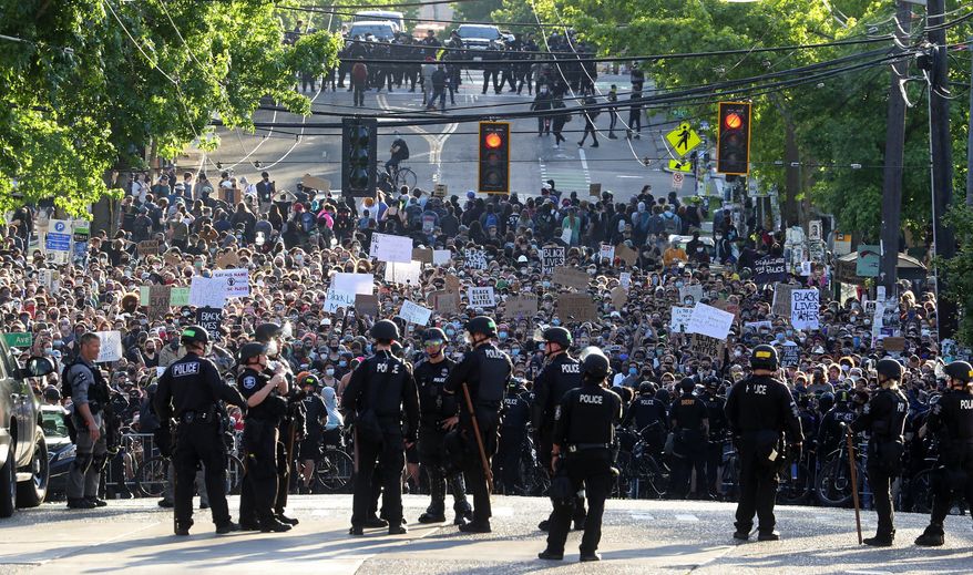A sea of peaceful protesters are kept back from the Seattle Police Department&#x27;s East Precinct on Capitol Hill, by a two-block buffer of officers and gates, seen in the foreground in Seattle, as demonstrations continue, sparked by the death of George Floyd in Minneapolis. (Ken Lambert/The Seattle Times via AP,File)