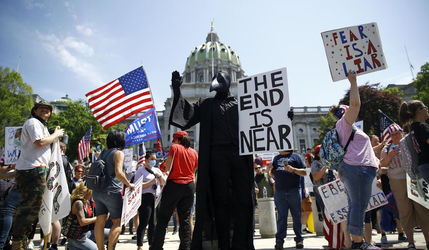 FILE - In this Friday, May 15, 2020 file photo, protesters hold a rally against Pennsylvania's coronavirus stay-at-home order at the state Capitol in Harrisburg, Pa. (AP Photo/Matt Rourke)