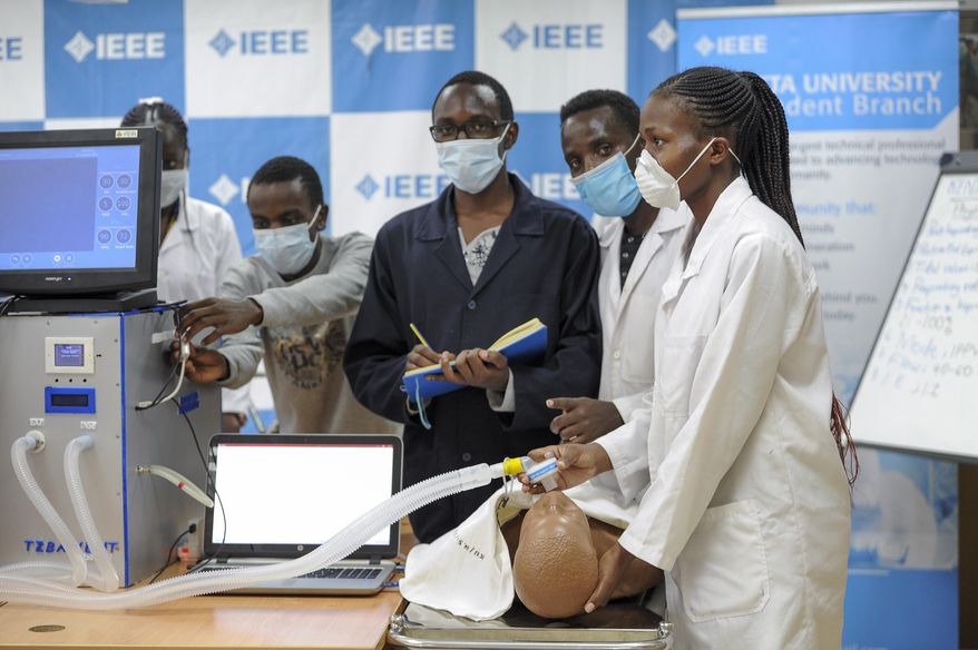 FILE - In this Monday, April 13, 2020 file photo, medical students test a self-designed computer-controlled ventilator prototype at the Chandaria Business and Incubation Centre of Kenyatta University in Nairobi, Kenya. More than two dozen international aid organizations have told the U.S. government they are "increasingly alarmed" that "little to no U.S. humanitarian assistance has reached those on the front lines" of the coronavirus pandemic as the number of new cases picks up speed in some of the world's most fragile regions. (AP Photo/John Muchucha, File)