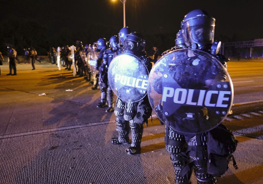 After demonstrators got onto I75 and shut down the interstate, police line up in riot gear in Atlanta, Saturday, June 13, 2020. Demonstrators were protesting the death of Rayshard Brooks, a black man who was shot and killed by Atlanta police Friday evening following a struggle in a Wendy&#39;s drive-thru line. (Ben Gray/Atlanta Journal-Constitution via AP)