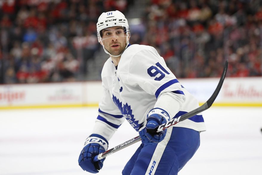 FILE - In this Nov. 27, 2019, file photo, Toronto Maple Leafs center John Tavares skates during the team's NHL hockey game against the Detroit Red Wings in Detroit. Tavares took his sticks home from the rink in Toronto to tape them up so he wouldn’t waste his limited time there. NHL players could start participating in voluntary small-group workouts, and teams began opening their training facilities Monday, June 8. Players learned Thursday training camps can open July 10, pending an agreement on returning to play later this summer, and they're now expected to trickle back in preparation of the resumption of the season. (AP Photo/Paul Sancya, File)