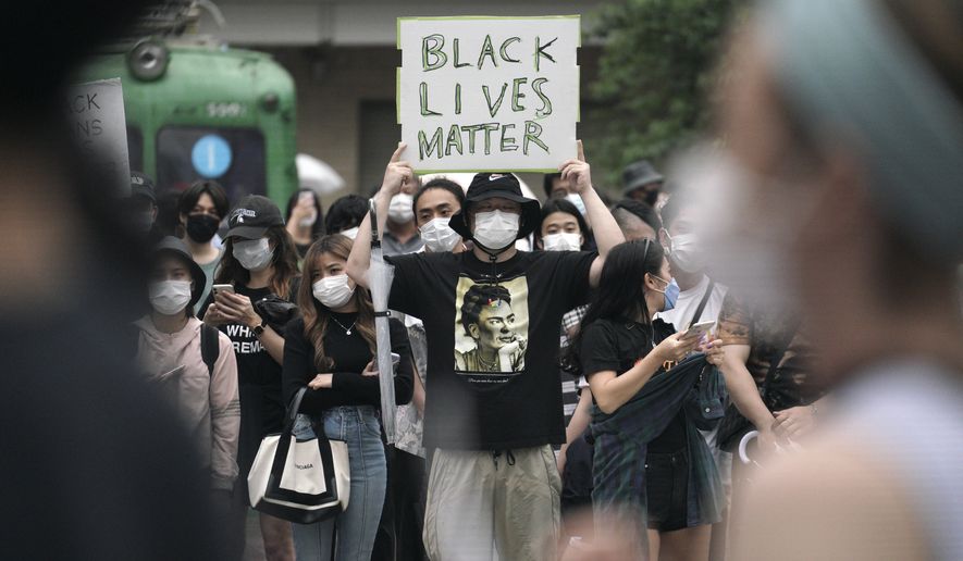 People gather to protest during a solidarity rally for the death of George Floyd in Tokyo Sunday, June 14, 2020. Floyd died after being restrained by Minneapolis police officers on May 25. Holding handmade signs that read “Black Lives Matter,” several hundred people marched peacefully at a Tokyo park Sunday, highlighting the outrage over the death of Floyd even in a country often perceived as homogeneous and untouched by racial issues. (AP Photo/Eugene Hoshiko)