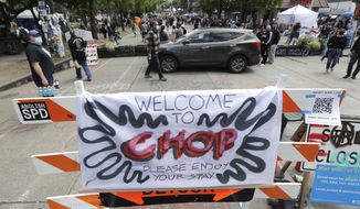 A sign reads &quot;Welcome to CHOP,&quot; Sunday, June 14, 2020, inside what has been named the Capitol Hill Occupied Protest zone in Seattle. Protesters calling for police reform and other demands have taken over several blocks near downtown Seattle after officers withdrew from a police station in the area following violent confrontations. The CHOP name is a change from CHAZ (Capitol Hill Autonomous Zone) that was used earlier in the week. (AP Photo/Ted S. Warren)