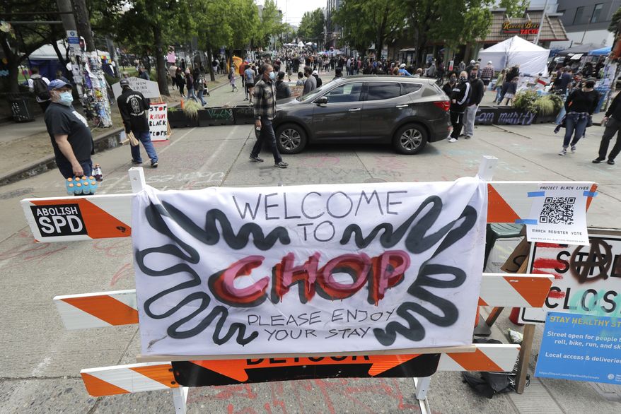 A sign reads &quot;Welcome to CHOP,&quot; Sunday, June 14, 2020, inside what has been named the Capitol Hill Occupied Protest zone in Seattle. Protesters calling for police reform and other demands have taken over several blocks near downtown Seattle after officers withdrew from a police station in the area following violent confrontations. The CHOP name is a change from CHAZ (Capitol Hill Autonomous Zone) that was used earlier in the week. (AP Photo/Ted S. Warren)