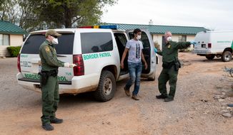 Border Patrol agents use personal protective equipment as they deal with people crossing into the U.S. illegally. Most crossers this year are single adult Mexicans, who are easily returned to their home country. (U.S. Customs and Border Protection)