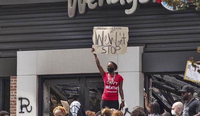 People hold a rally at Wendy&#x27;s on University Avenue in Atlanta on Sunday, June 14, 2020. Rayshard Brooks died after a confrontation with police officers at the fast-food restaurant in Atlanta on Friday. (Steve Schaefer/Atlanta Journal-Constitution via AP)