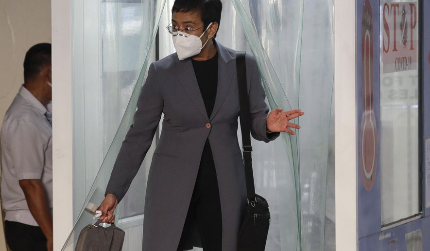Rappler CEO and Executive Editor Maria Ressa, wearing a protective mask, exits a disinfection area before attending a court hearing at Manila Regional Trial Court, Philippines on Monday June 15, 2020. Ressa&#x27;s verdict is expected to be announced Monday for a cyber libel case. (AP Photo/Aaron Favila)