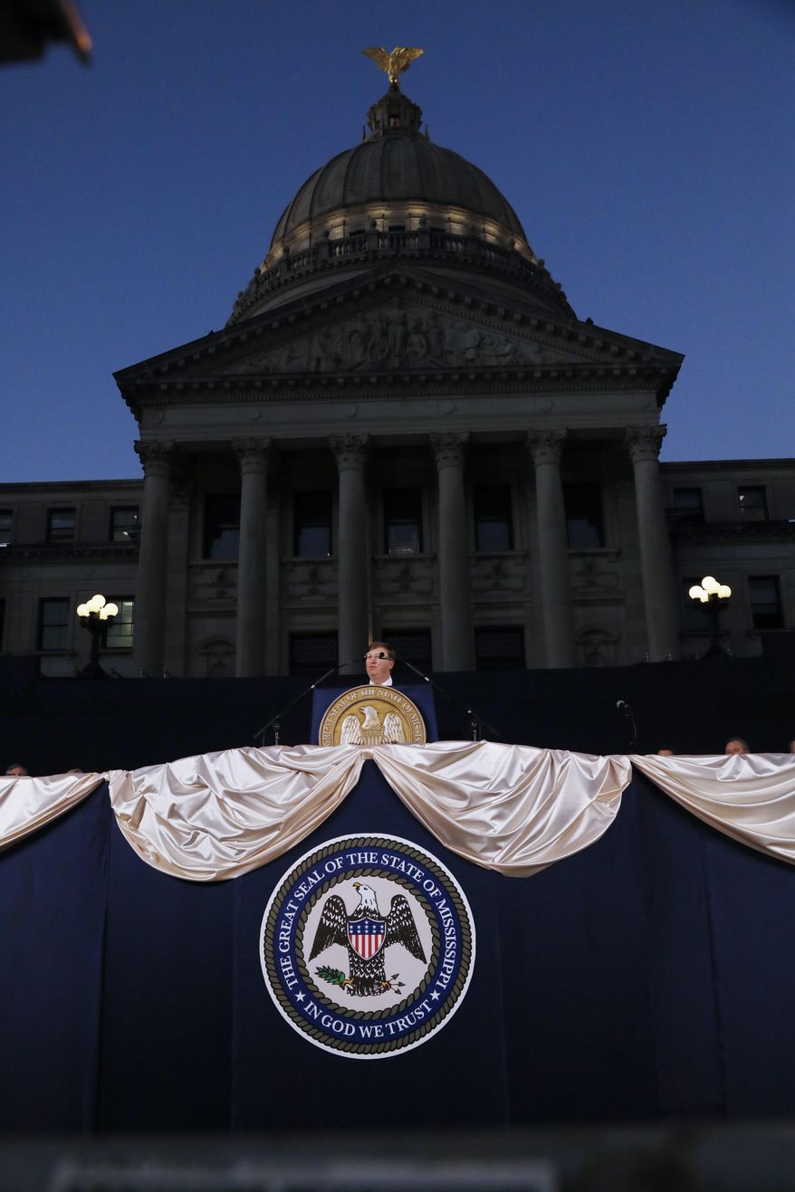 Gov. Tate Reeves delivers his State of the State address before a joint session of the Legislature, seated outside the darkened Mississippi Capitol in Jackson, Miss., Monday, Jan. 27, 2020. (AP Photo/Rogelio V. Solis)