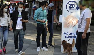 People wearing face masks to protect against the new coronavirus, use disinfectant at the entrance of a public garden, in Ankara, Turkey, Sunday, June 14, 2020. Turkey&#39;s President Recep Tayyip Erdogan has revealed Tuesday new plans to ease restrictions in place to curb the spread of the coronavirus, including the July 1 reopening of theaters, cinemas and other entertainment centers.(AP Photo/Burhan Ozbilici)