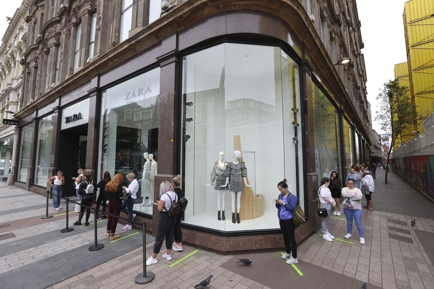 Shoppers queue outside Zara in Belfast, northern Ireland, Monday, June 15, 2020. After three months of being closed under coronavirus restrictions, shops selling fashion, toys and other non-essential goods are being allowed to reopen across England for the first time since the country went into lockdown in March. (Liam McBurney/PA via AP)