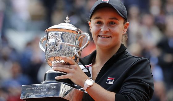 FILE - In this June 8, 2019, file photo, Australia&#39;s Ash Barty holds the trophy as she celebrates winning her women&#39;s final match of the French Open tennis tournament against Marketa Vondrousova of the Czech Republic in two sets 6-1, 6-3, at the Roland Garros stadium in Paris. Barty has joined the ranks of high-profile players expressing concern over the staging of the U.S. Open while there’s still so much uncertainty in the coronavirus pandemic. The women’s No. 1 hasn’t had the chance yet to defend her French Open title because all elite tennis competition is shuttered. (AP Photo/Christophe Ena, File)