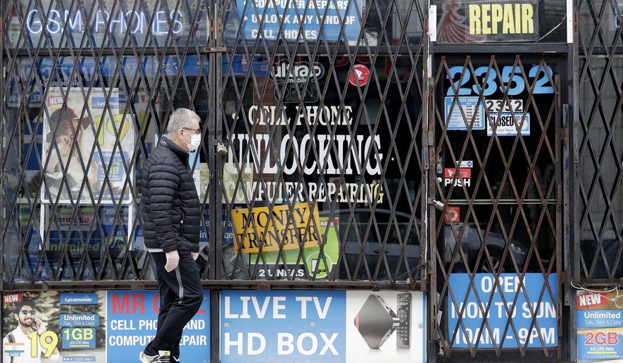 FILE - In a April 30, 2020 file photo, a man walks by a closed store during the COVID-19 in Chicago. Layoffs are declining and hiring is slowly picking up, yet it's not really clear where the job market goes next. (AP Photo/Nam Y. Huh, File)