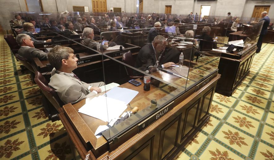 Rep. Charlie Baum, R-Murfreesboro, front left, and other House members sit behind glass partitions due to the coronavirus pandemic during a House session Tuesday, June 9, 2020, in Nashville, Tenn. (AP Photo/Mark Humphrey)
