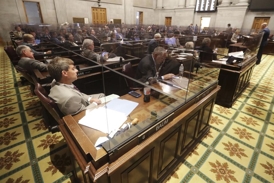 Rep. Charlie Baum, R-Murfreesboro, front left, and other House members sit behind glass partitions due to the coronavirus pandemic during a House session Tuesday, June 9, 2020, in Nashville, Tenn. (AP Photo/Mark Humphrey)