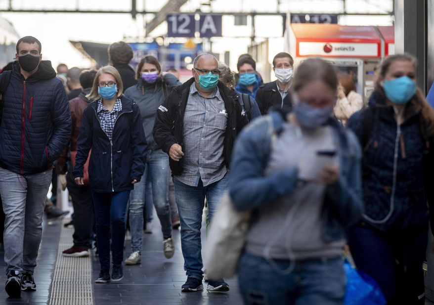 FILE - In this April 27, 2020, file photo, passengers wearing face masks arrive in the main train station in Frankfurt, Germany. Germany launched a coronavirus tracing app Tuesday, June 16, 2020, that officials say is so secure even government ministers can use it. Smartphone apps have been touted as a high-tech tool in the effort to track down potential COVID-19 infections. But governments in privacy-conscious Europe have run into legal and cultural hurdles trying to reconcile the need for effective tracing with the continent’s strict data privacy standards. (AP Photo/Michael Probst, File)