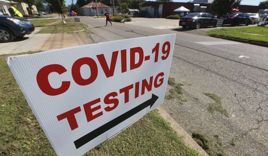 In this Thursday, June 11, 2020 photo, signs line the street along South Church Street in Tupelo, Miss., to let drivers know where to go for free COVID-19 testing at the Family Resource Center. (Thomas Wells/The Northeast Mississippi Daily Journal via AP)