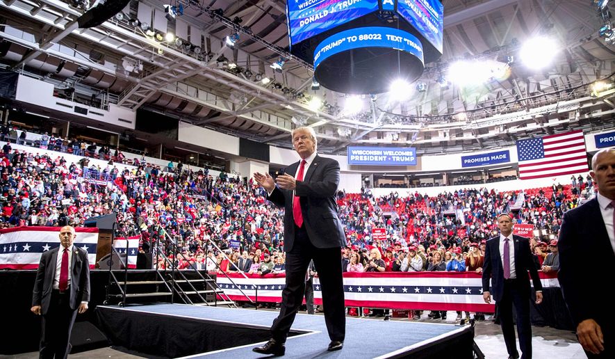 President Trump arrives at a campaign rally in Wisconsin in late 2019, and claps along with a large friendly crowd. (Associated Press)