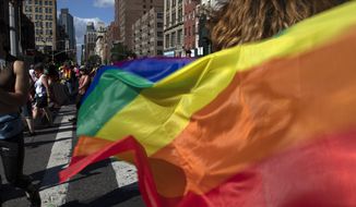 In this June 30, 2019, photo, paradegoers carrying rainbow flags walk down a street during the LBGTQ Pride march in New York, to celebrate five decades of LGBTQ pride, marking the 50th anniversary of the police raid that sparked the modern-day gay rights movement. Democrats flooded Twitter and email inboxes this week with praise for the watershed Supreme Court decision shielding gay, lesbian and transgender people from job discrimination. (AP Photo/Wong Maye-E) **FILE**