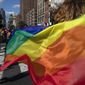 In this June 30, 2019, photo, paradegoers carrying rainbow flags walk down a street during the LBGTQ Pride march in New York, to celebrate five decades of LGBTQ pride, marking the 50th anniversary of the police raid that sparked the modern-day gay rights movement. (AP Photo/Wong Maye-E) ** FILE **