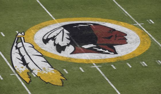 In this Aug. 7, 2014 file photo, the Washington Redskins NFL football team logo is seen on the field before an NFL football preseason game against the New England Patriots in Landover, Md. A group of investment firms are pushing companies like FedEx, which has naming rights for the Redskins stadium, to dissociate from the NFL team unless it changes its name. (AP Photo/Alex Brandon, File)