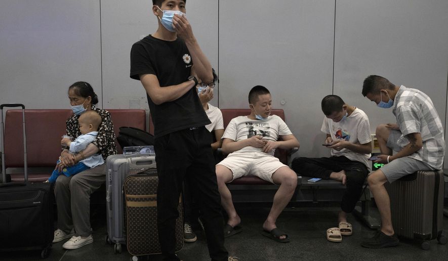 Passengers wait for their flight at the Beijing Capital Airport terminal 2 in Beijing on Wednesday, June 17, 2020. The Chinese capital on Wednesday canceled more than 60% of commercial flights and raised the alert level amid a new coronavirus outbreak, state-run media reported. (AP Photo/Ng Han Guan)