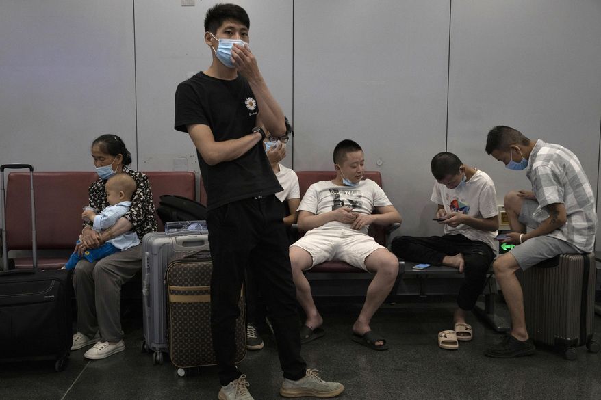 Passengers wait for their flight at the Beijing Capital Airport terminal 2 in Beijing on Wednesday, June 17, 2020. The Chinese capital on Wednesday canceled more than 60% of commercial flights and raised the alert level amid a new coronavirus outbreak, state-run media reported. (AP Photo/Ng Han Guan)