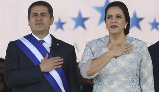 FILE - In this Jan. 27, 2018 file photo, Honduran President Juan Orlando Hernandez, left, stands with his wife Ana Garcia, during the presidential inauguration ceremony for his second term at the National Stadium in Tegucigalpa, Honduras. Hernández and his wife have tested positive for COVID-19, the Central American leader said late Tuesday, June 16, 2020, in a television message. (AP Photo/Fernando Antonio, File)