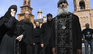 Father Sergiy, a Russian monk who has defied the Russian Orthodox Church&#39;s leadership, right, speaks to journalists in Russian Ural&#39;s Sredneuralsk, Russia, Wednesday, June 17, 2020. The monk, who has denied the coronavirus&#39; existence and urged believers to ignore the Kremlin&#39;s lockdown orders, has taken control of a monastery in the Ural Mountains. (AP Photo/Vladimir Podoksyonov)