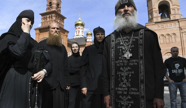 Father Sergiy, a Russian monk who has defied the Russian Orthodox Church&#x27;s leadership, right, speaks to journalists in Russian Ural&#x27;s Sredneuralsk, Russia, Wednesday, June 17, 2020. The monk, who has denied the coronavirus&#x27; existence and urged believers to ignore the Kremlin&#x27;s lockdown orders, has taken control of a monastery in the Ural Mountains. (AP Photo/Vladimir Podoksyonov)