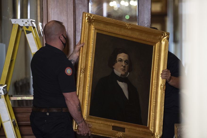 Architect of the Capitol workers remove a portrait of Howell Cobb of Georgia that was hanging in the Speakers Lobby on Capitol Hill, Thursday, June 18, 2020, in Washington. (Nicholas Kamm/Pool via AP)