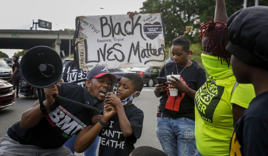 Protesters yells "Black Lives Matter" in the street near a Wendy's restaurant on Wednesday, June 17, 2020 in Atlanta. The restaurant was where Rayshard Brooks was shot and killed by police. Fulton County District Attorney Paul L. Howard Jr. announced former Atlanta Police Officer Garrett Rolfe faces charges including felony murder in the fatal shooting of Rayshard Brooks on June 12. (AP Photo/Brynn Anderson)
