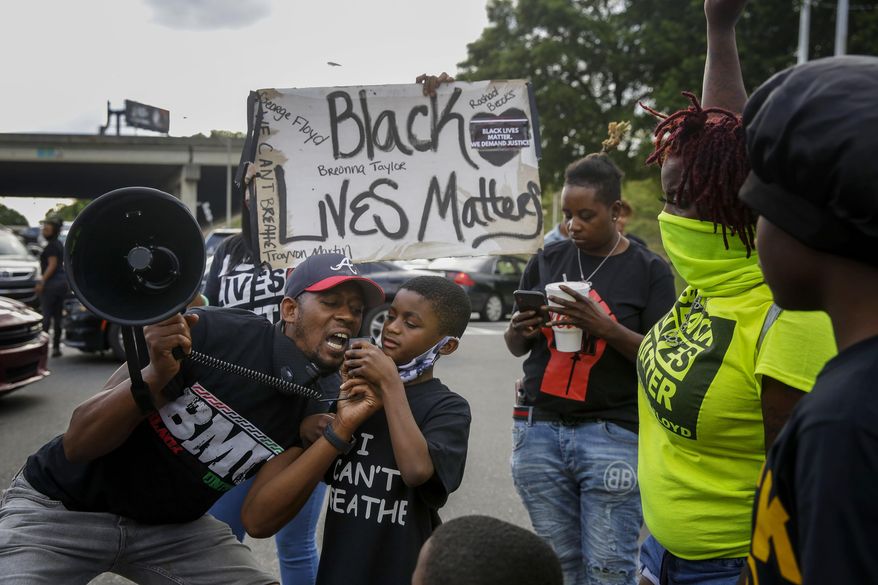 Protesters yells "Black Lives Matter" in the street near a Wendy's restaurant on Wednesday, June 17, 2020 in Atlanta. The restaurant was where Rayshard Brooks was shot and killed by police. Fulton County District Attorney Paul L. Howard Jr. announced former Atlanta Police Officer Garrett Rolfe faces charges including felony murder in the fatal shooting of Rayshard Brooks on June 12. (AP Photo/Brynn Anderson)