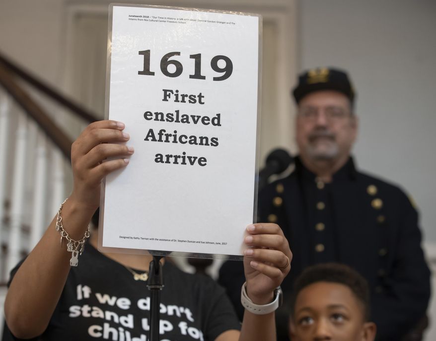 FILE - In this June 19, 2019, file photo, a staff member from the Freedom School holds up a card during a presentation at the 40th Annual Al Edwards' Juneteenth Prayer Breakfast at Ashton Villa in Galveston, Texas. Juneteenth, the holiday that commemorates the end of slavery in the United States, originated 155 years ago. (Stuart Villanueva/The Galveston County Daily News via AP, File)