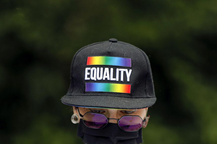 A protester stands outside the presidential palace in Bucharest, Romania, Thursday, June 18, 2020, during a rally against a law banning the teaching of gender studies. Dozens of protesters gathered outside Bucharest's Cotroceni Presidential Palace, to express their opposition to a law banning the teaching of gender studies in the country's schools and universities and call on President Klaus Iohannis to reject signing the bill and send it back to parliament. (AP Photo/Vadim Ghirda)