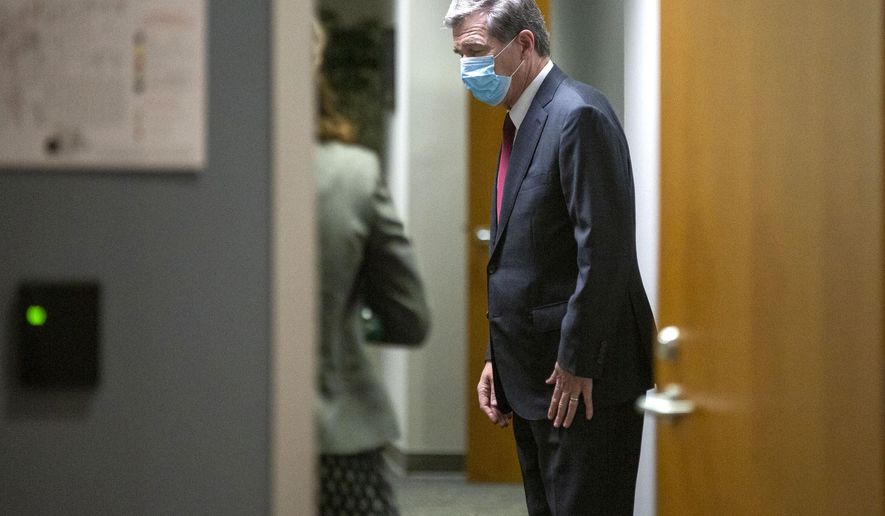 Gov. Roy Cooper heads back inside the N.C. Emergency Operations Center after speaking during a press conference on North Carolina's coronavirus pandemic response Monday, Jun. 15, 2020./The News & Observer via AP)