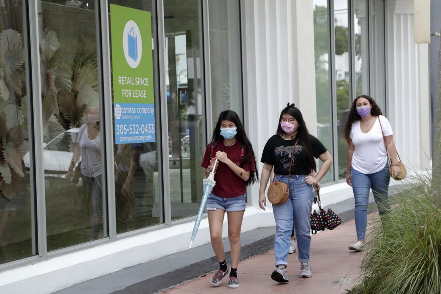 Shoppers wear protective face coverings as they walk past a vacant retail store for lease at Lincoln Road Mall during the new coronavirus pandemic, Wednesday, June 17, 2020, in Miami Beach, Fla. (AP Photo/Lynne Sladky)