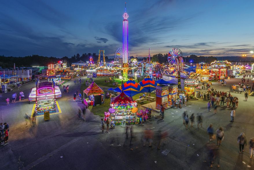 FILE - In this Aug. 9, 2018, file photo, fair-goers attend The State Fair of West Virginia at the State Fairgrounds in Fairlea, W.Va. The State Fair of West Virginia has been canceled due to a coronavirus outbreak in the county where the event was set to take place. The fair’s board of directors, which last week had voted to move ahead with the event, said Thursday, June 18, 2020 that an unfolding virus flareup linked to a church in Greenbrier County has caused them to scrap the festival for the first time since World War II. (Craig Hudson/Charleston Gazette-Mail via AP, File)