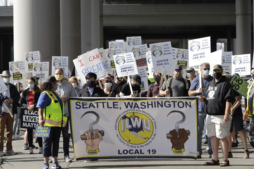 Union workers and other supporters march Friday, June 19, 2020, near the Port of Seattle as part of a coordinated eight-hour work stoppage at more than two dozen West Coast Ports that was organized by the International Longshore and Warehouse Union. Workers took part in rallies honoring Juneteenth and to protest against police violence and racism. (AP Photo/Ted S. Warren)