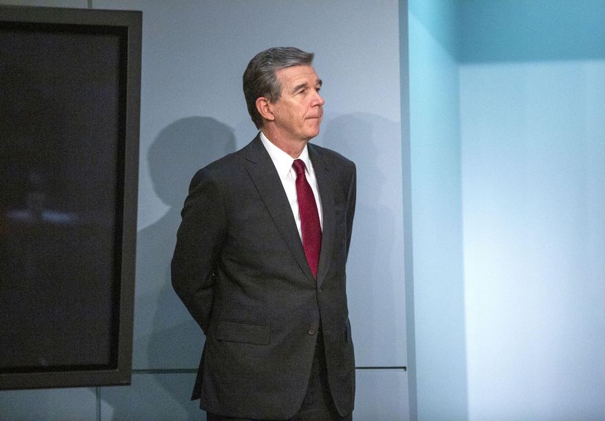 North Carolina Gov. Roy Cooper listens as N.C. DHHS Secretary Dr. Mandy Cohen speaks during a briefing on North Carolina's coronavirus pandemic response Monday, June 15, 2020, at the N.C. Emergency Operations Center in Raleigh, N.C. (Casey Toth/The News & Observer via AP)