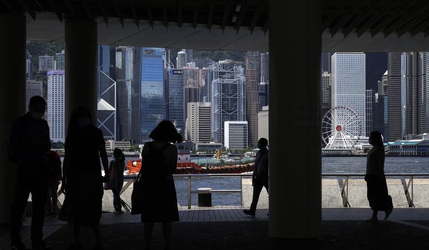 People walk at the waterfront of the Victoria Harbor of Hong Kong, Saturday, June 20, 2020. China's top legislative body has taken up a draft national security law for Hong Kong that has been strongly criticized as undermining the semi-autonomous territory's legal and political institutions. (AP Photo/Kin Cheung)