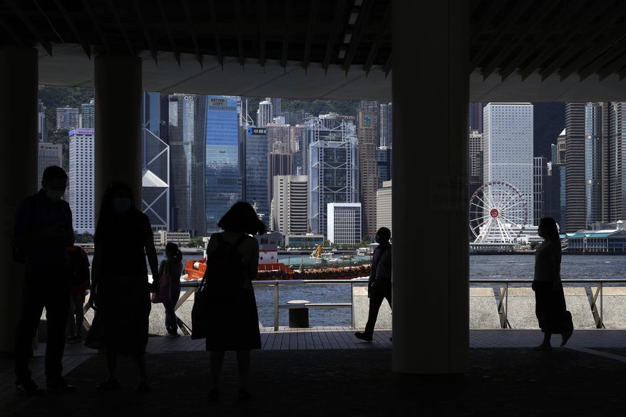 People walk at the waterfront of the Victoria Harbor of Hong Kong, Saturday, June 20, 2020. China's top legislative body has taken up a draft national security law for Hong Kong that has been strongly criticized as undermining the semi-autonomous territory's legal and political institutions. (AP Photo/Kin Cheung)