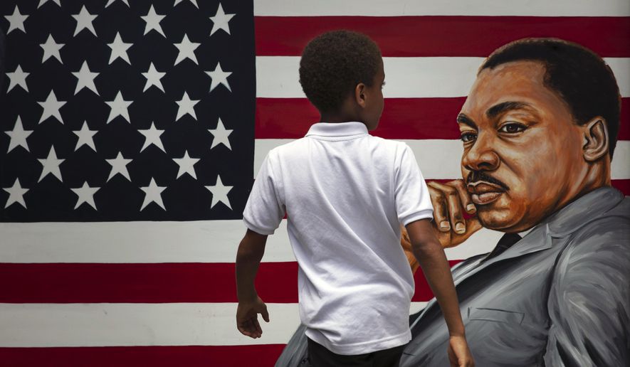 A young boy walks past a painting of Dr. Martin Luther King Jr. during a Juneteenth celebration in Los Angeles. Friday, June 19, 2020. Juneteenth marks the day in 1865 when federal troops arrived in Galveston, Texas, to take control of the state and ensure all enslaved people be freed, more than two years after the Emancipation Proclamation. (AP Photo/Jae C. Hong)