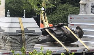 The statue of a Confederate soldier and plinth sit on a flatbed truck at the Old Capitol in Raleigh, N.C., on Sunday, June 21, 2020. After protesters pulled down two smaller statues on the same monument Friday, North Carolina Gov. Roy Cooper ordered the removal of several other monuments to the Confederacy, citing public safety concerns. (AP Photo/Allen G. Breed)