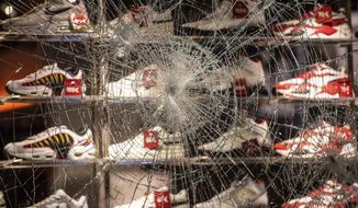 A window of a shop for shoes is destroyed at the  Koenigstrasse in Stuttgart, Germany, Sunday, June 21, 2020. Dozens of violent small groups devastated downtown Stuttgart on Sunday night and injured several police officers, German news agency DPA reported. (Christoph Schmidt/dpa via AP)