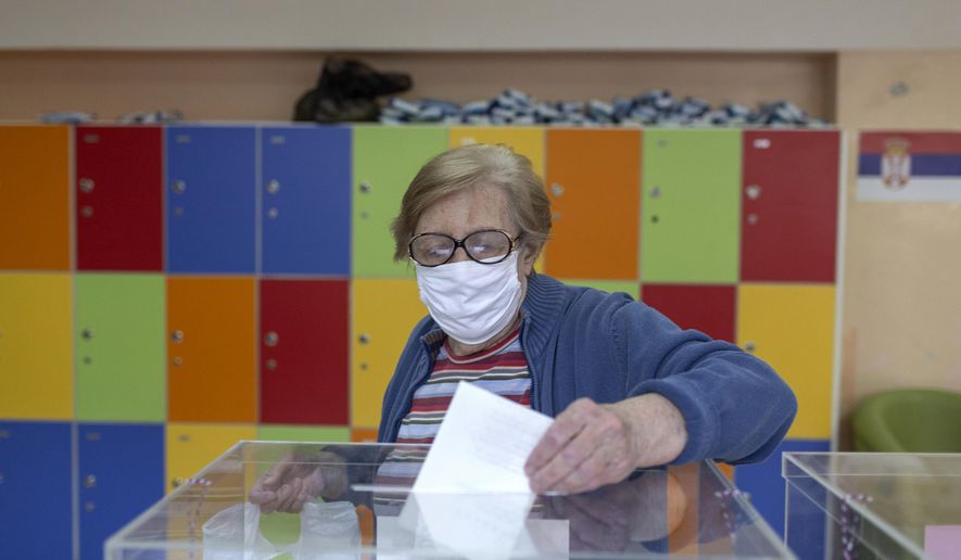 A woman casts her ballot at a polling station in Belgrade, Serbia, Sunday, June 21, 2020. Serbia&#39;s ruling populists are set to tighten their hold on power in a Sunday parliamentary election held amid concerns over the spread of the coronavirus in the Balkan country and a partial boycott by the opposition. (AP Photo/Marko Drobnjakovic)