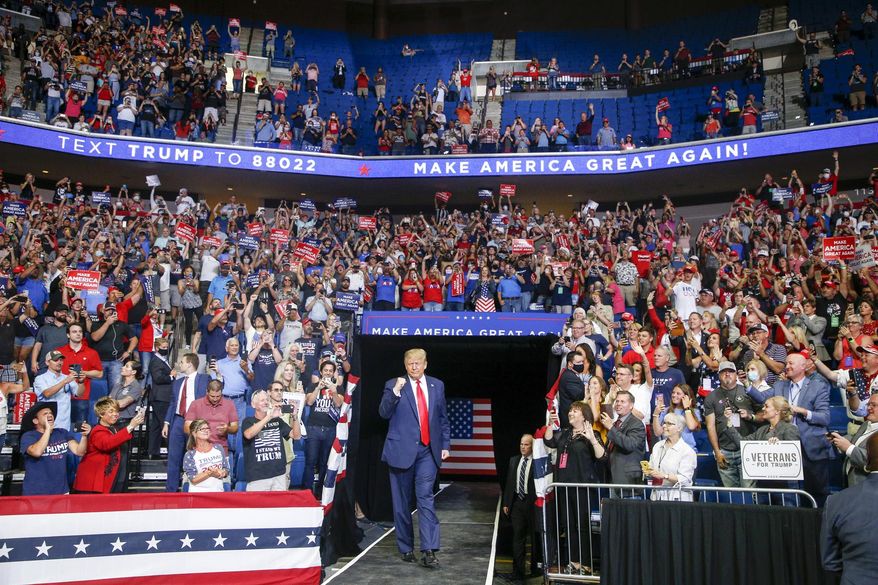 President Donald Trump, center, walk toward the stage while supporters cheer during his campaign rally at BOK Center in Tulsa, Okla., Saturday, June 20, 2020. (Ian Maule/Tulsa World via AP)
