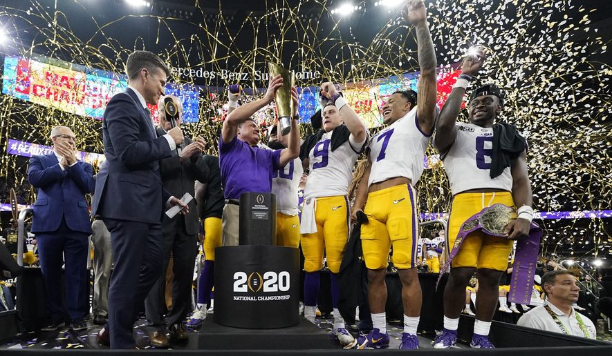 FILE - In this Jan. 13, 2020, file photo, LSU head coach Ed Orgeron holds the trophy after the team's victory over Clemson in an NCAA College Football Playoff national championship game in New Orleans. LSU has begun asking a number of football players to self-quarantine in the past week because of instances in which some players tested positive for COVID-19 after social interactions outside of the Tigers’ training facility. (AP Photo/David J. Phillip, File)