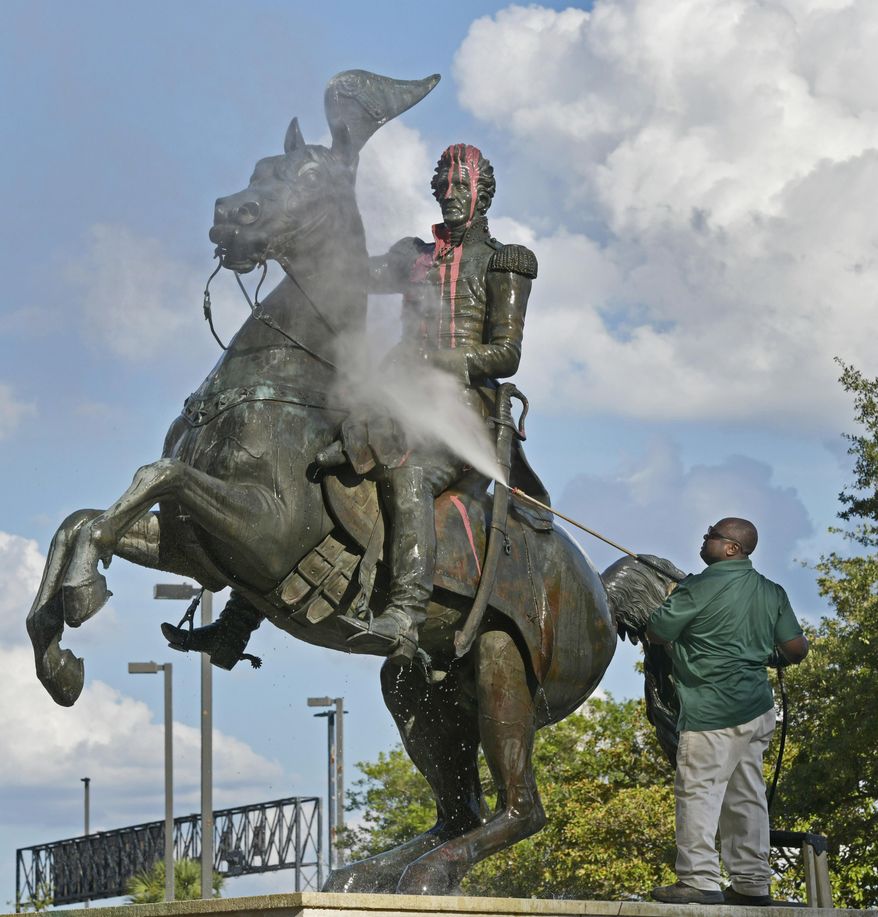 In this file photo, Ronnie English, a City of Jacksonville worker, pressure-washes the statue of Andrew Jackson after it was defaced with paint Monday, June 22, 2020, in downtown Jacksonville, Fla. (Will Dickey/The Florida Times-Union via AP)  **FILE**